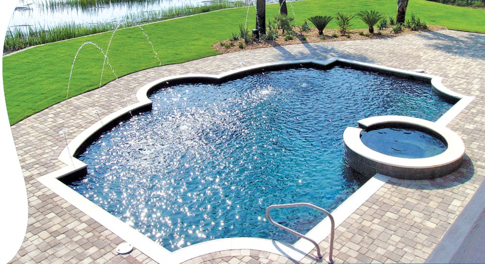 Geometric swimming pool with spa and paverstone deck.