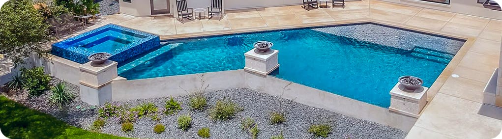 Sleek geometric gunite pool with square rimflow spa and tanning ledge.