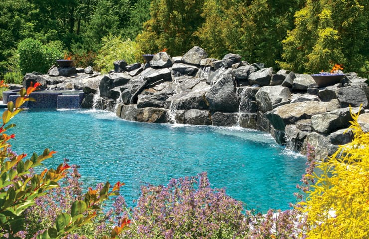 Sprawling rock waterfall along inground pool.
