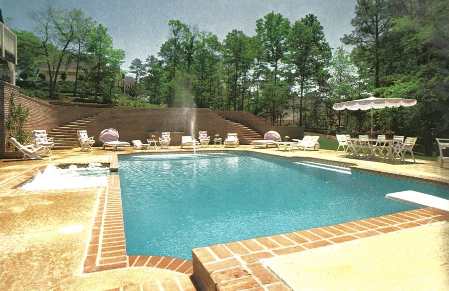 1970s- inground pool with red brick coping around perimeter.