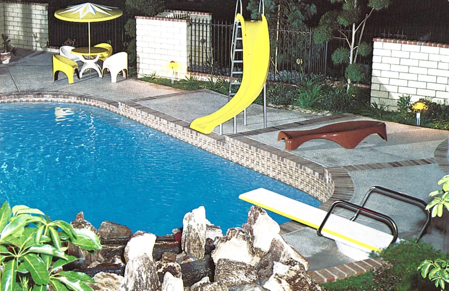 Yellow pool slide on mid-century inground pool.