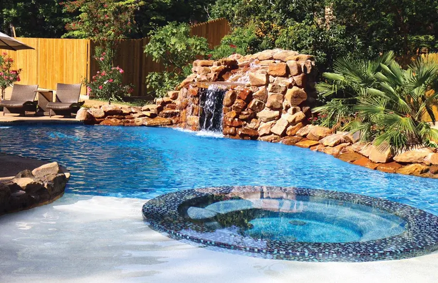 Swimming pool with rock grotto waterfall and spa.