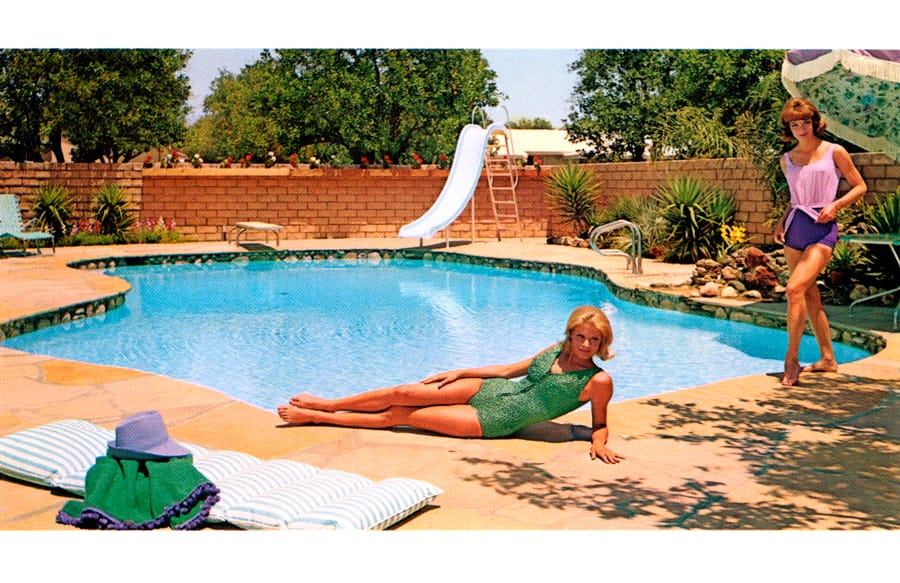 Two women in 1960s lounging by a Blue Haven pool. 