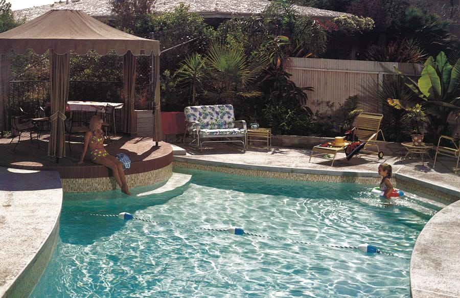 Mid-century geometric inground pool in backyard.