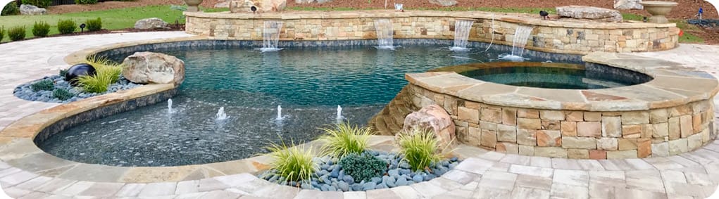 Free-form gunite pool and spa with integrated lansdcape pockets and bubbler-fountains on tanning ledge.