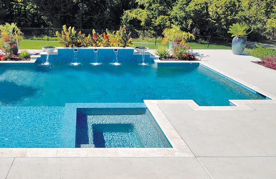 Sleek square spa on geometric-shape custom pool.