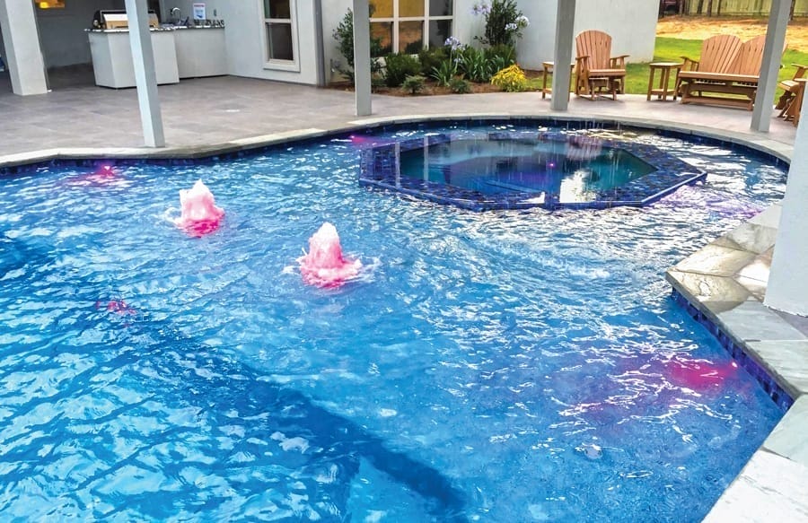 Swimming pool with hexagon spa and bubbler fountains.