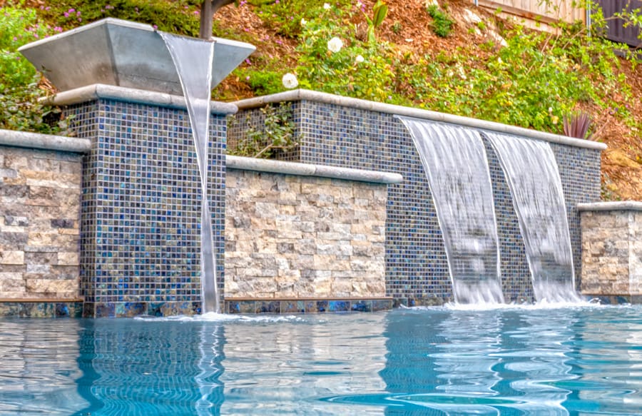 Decorative water bowl and twin cascade waterfalls on swimming pool.