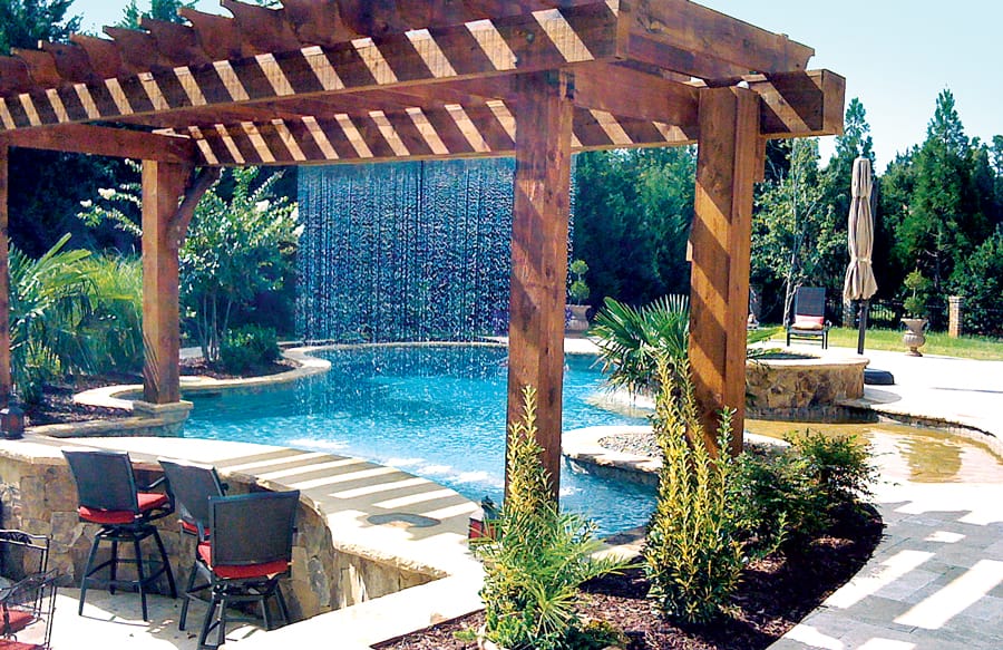 Pergola with teardrop rain-curtain-style water feature on pool.