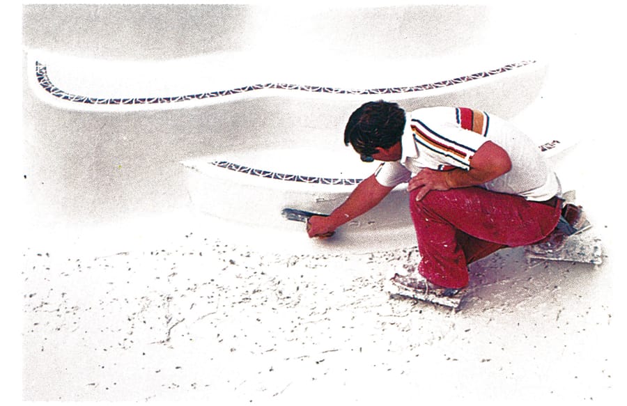 1980s construction worker plastering the steps of a swimming pool.