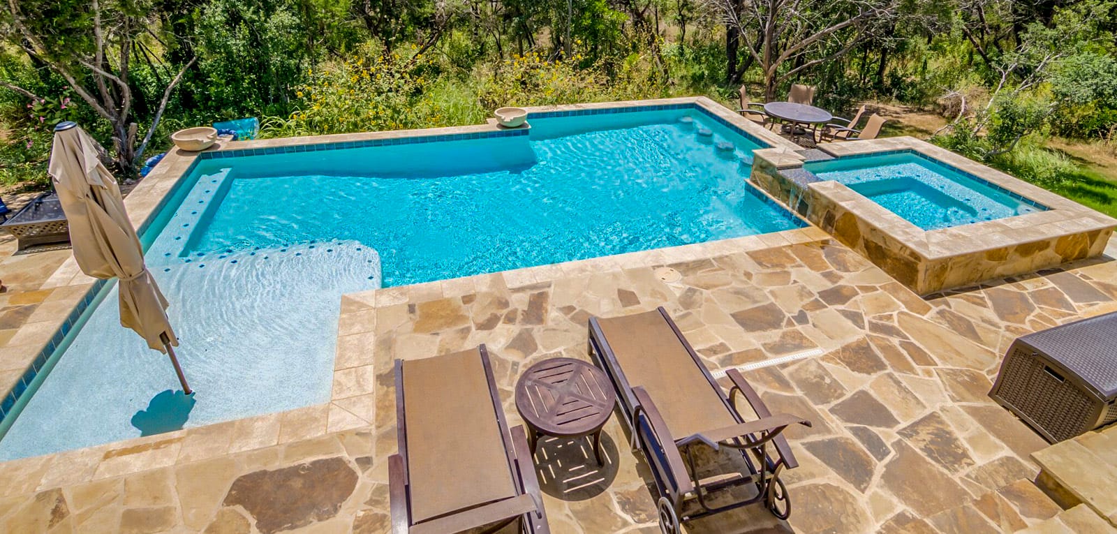 Overhead view of gunite pool with spa, swim-up bar, and flagstone deck.