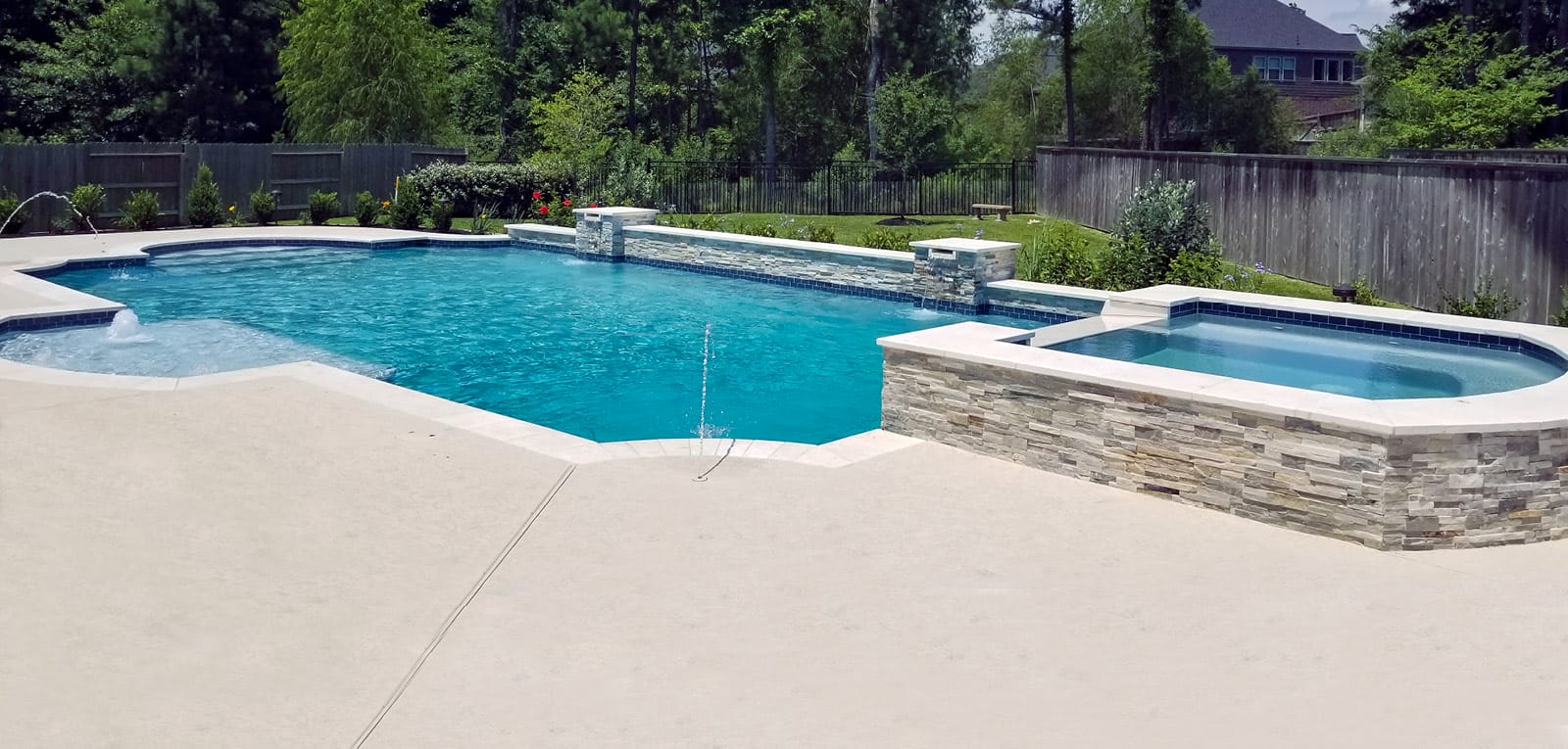 Roman swimming pool with raised spa, fountains, cascades, and laminar water features.