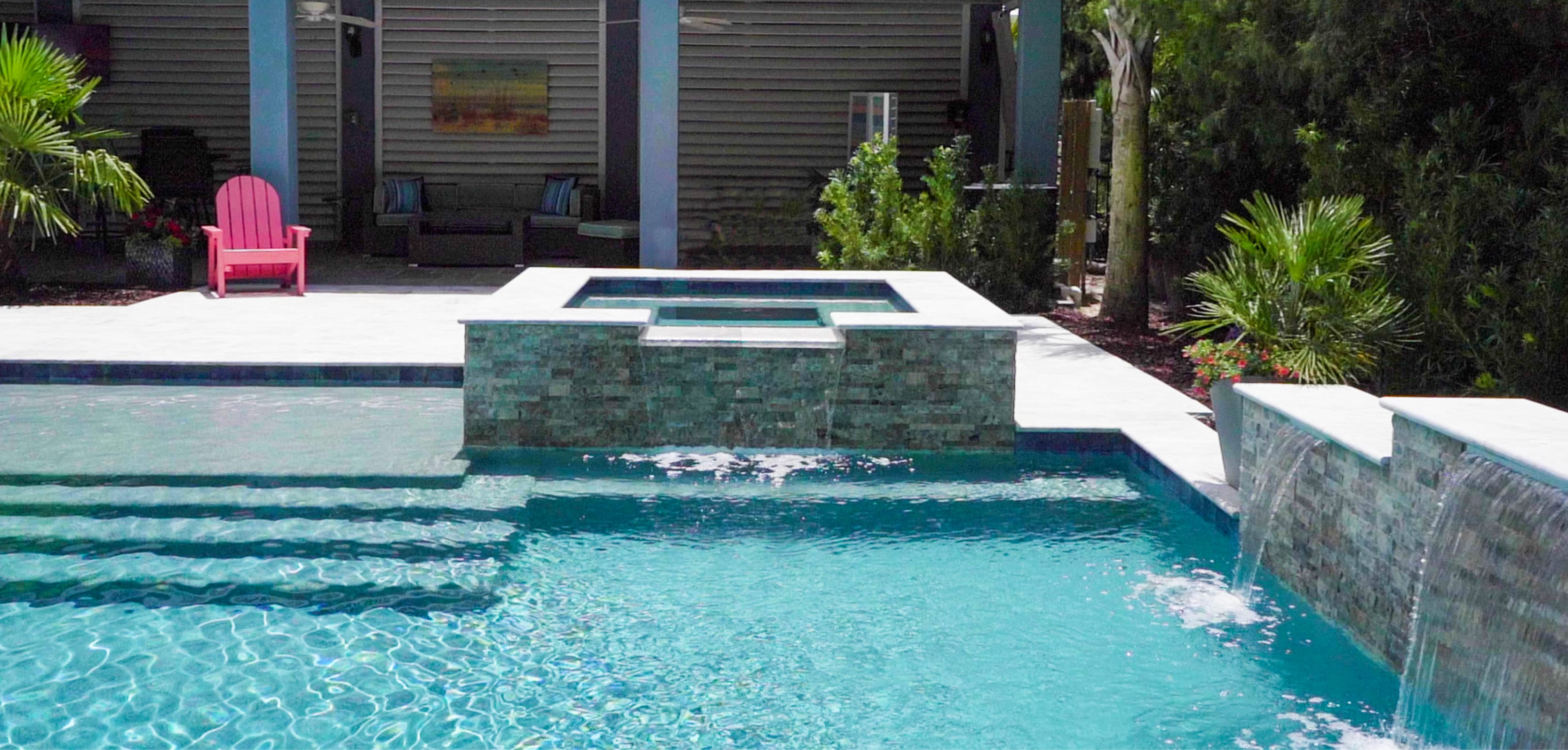 Swimming pool with square spa, large entry steps, and sheer descent water features.