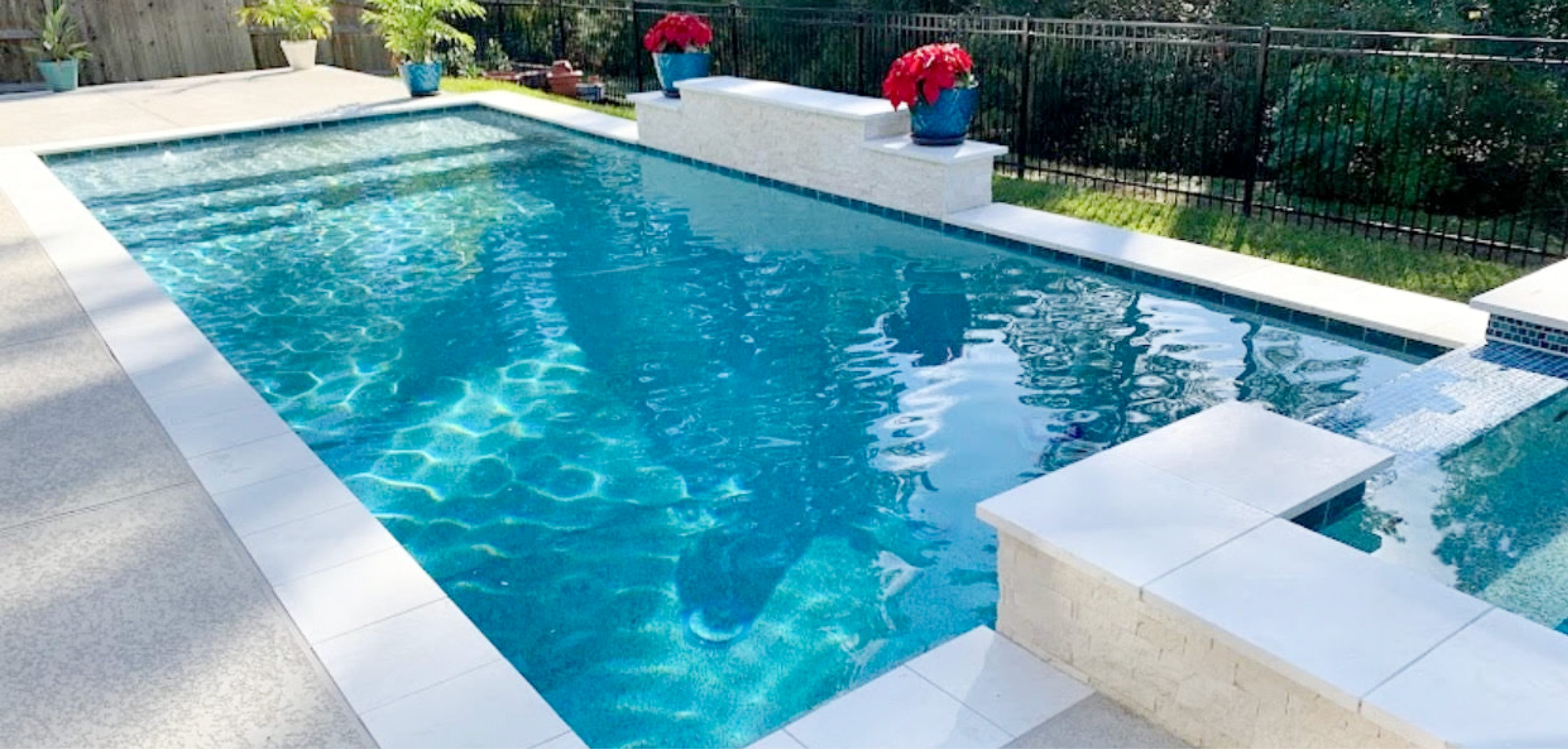 Backyard swimming pool with square spa.
