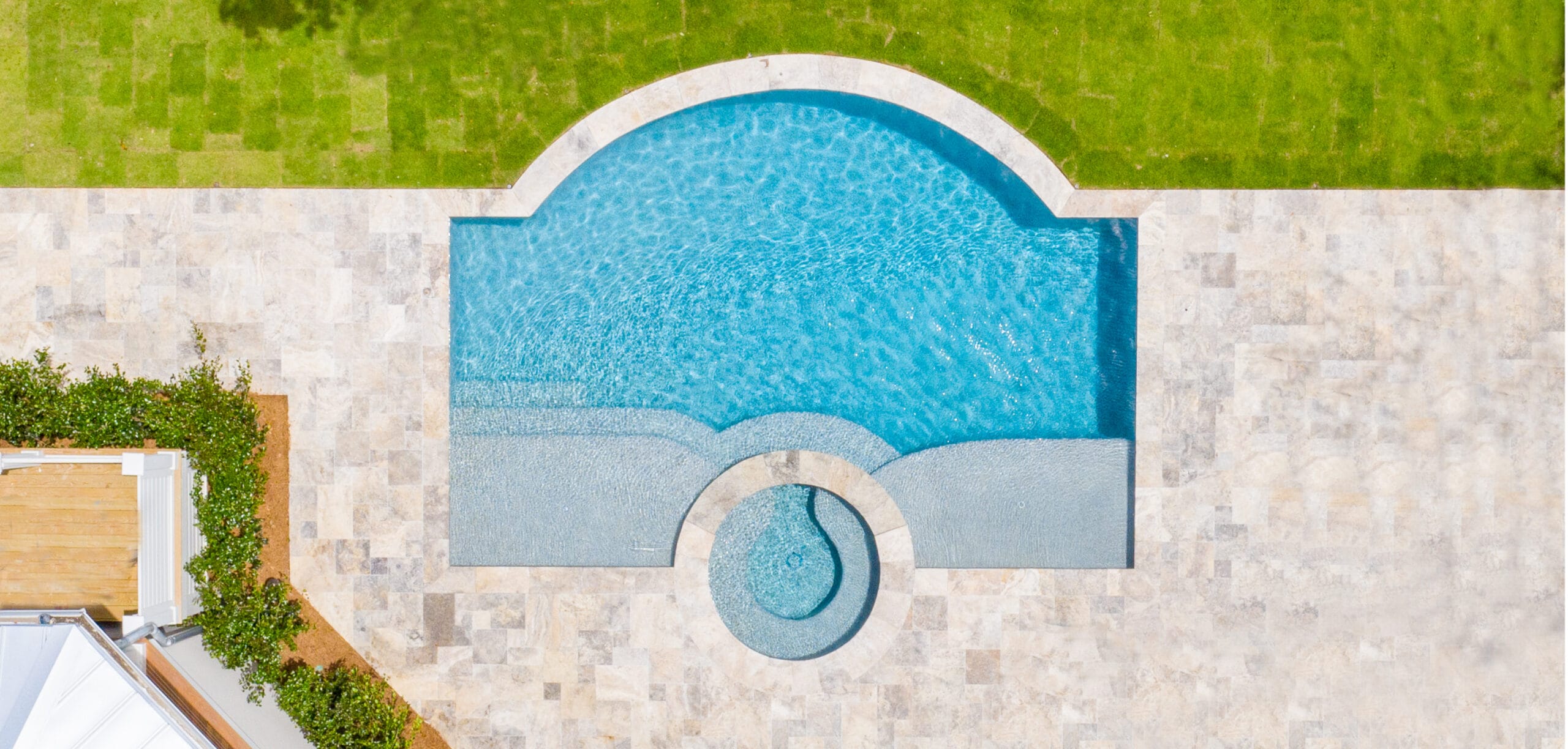 overhead view of sleek geometric swimming pools with one fully arcing side. 